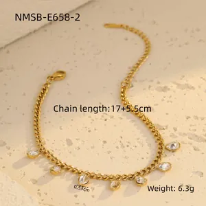 Détail du collier en acier doré avec cristaux en goutte d'eau sur fond de pierre