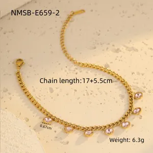 Détail du collier en acier doré avec breloques en cristal rose ovale sur fond de pierre