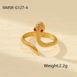 Détail macro d'une bague serpent dorée avec des yeux en pierres rouges et des écailles