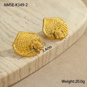 Détail des boucles d'oreilles dorées à l'or 18 carats avec tortue et coquillage