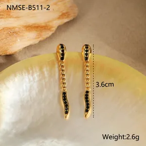 Détail macro de boucles d'oreilles serpent dorées avec pierres noires, 3.6cm et 2.6g