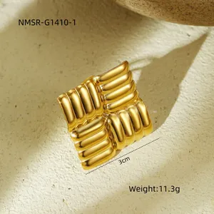 Detailopname van gouden vierkante ring van 3 cm met getextureerde afwerking op de achtergrond