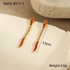 Détail de longues boucles d'oreilles serpent dorées avec pierres rouges de 3,6 cm