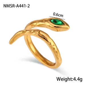 Détail d'une bague serpent dorée avec gemme marquise verte et texture martelée fine