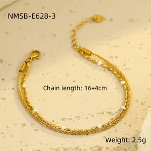 Detail eines 18K vergoldeten Edelstahlarmbandes mit weißen Perlen im Lagenlook