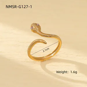 Détail d'une bague serpent dorée ajustable avec yeux roses et texture d'écailles