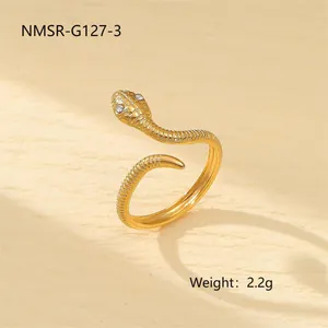 Détail d'une bague serpent dorée avec yeux en cristal blanc et texture de peau fine