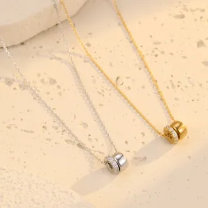 Colliers élégants avec pendentifs double anneau en zircon or et argent sur fond de pierre