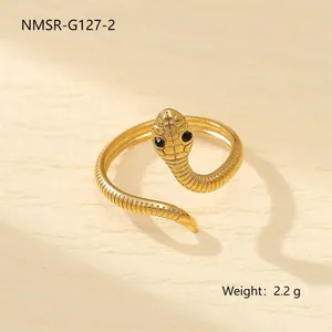 Vue détaillée d'une bague serpent dorée avec texture d'écailles et yeux en pierre noire