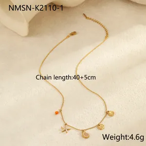 Detail van gouden kralenketting met zeester- en schelphangers op een beige achtergrond