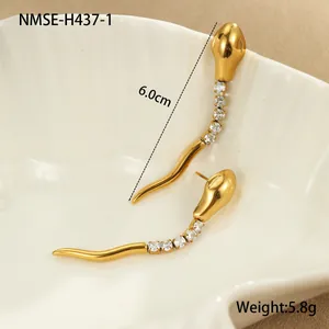 Détail de boucles d'oreilles pendantes dorées avec oxydes de zirconium