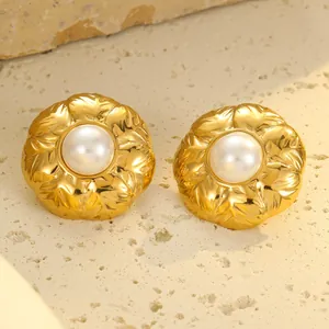 Boucles d'oreilles fleurs en acier doré 18k avec perles sur un support en pierre