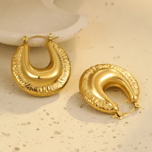 Gros plan de boucles d'oreilles en U plaquées or 18K avec des détails de texture fins