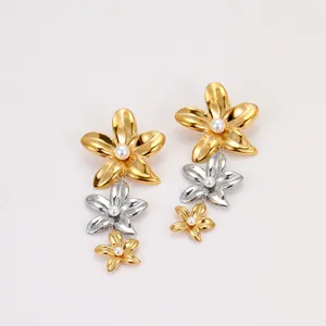 Boucles d'oreilles fleurs à trois couches bicolores avec perle centrale sur fond blanc