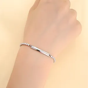 Detalle de una pulsera de acero inoxidable plateado con placa rectangular y cristales