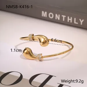 Detail view of gold open bangle with pearl accents showing 6.6cm inner diameter and weight
