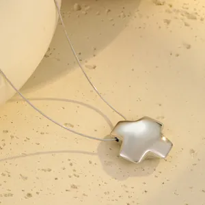Nahaufnahme eines minimalistischen Silberstern-Anhängers an einer Schlangenkette