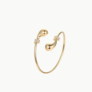 Minimalist open gold bangle with teardrop ends and sparkling crystal inlay details