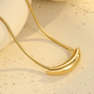 Makroaufnahme einer minimalistischen Gold-Schlangenkette mit glattem geometrischem Anhänger