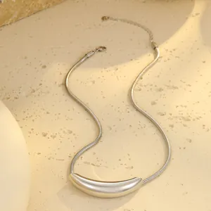 Nahaufnahme der silbernen Schlangenkette mit Mondanhänger auf Steinoberfläche