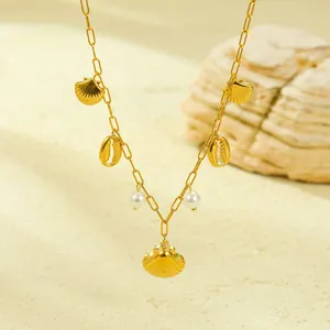 Detailed shot of a gold ocean necklace with shell pendants and pearls on sandy background