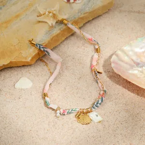 Marine style stainless steel necklace with gold shell pendant and pink floral ribbon