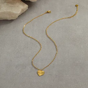 Detail of gold heart pendant with radial texture and lobster clasp on fine chain
