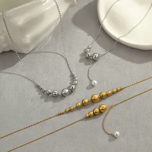 Colliers en acier inoxydable plaqué or 18 carats avec perles sur fond gris