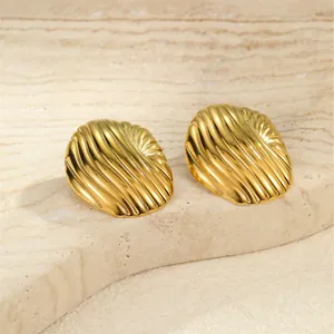 Strukturierte goldene Edelstahl-Ohrstecker mit Rippenmuster auf Steinoberfläche