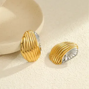 Makroaufnahme von zweifarbigen gold-silbernen ovalen Ohrsteckern mit Muscheltextur