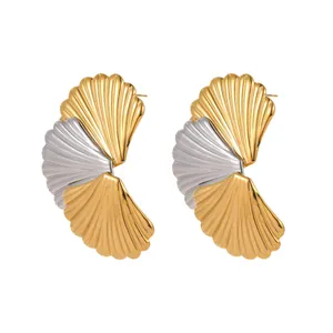 Makro-Detail fächerförmiger Faltenohrringe mit poliertem Gold- und Silberton-Finish