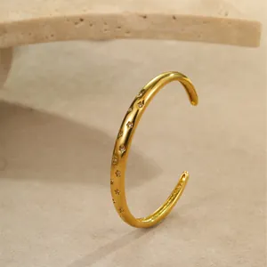 Gepolijste gouden roestvrijstalen armband met gegraveerde sterren en glanzende zirkoon