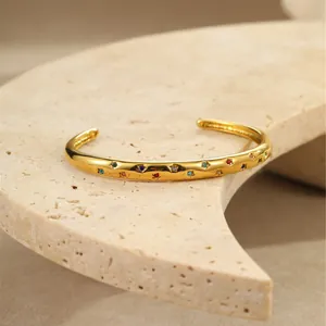 Detail van de gouden roestvrijstalen armband met veelkleurige stervormige stenen
