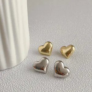 Polished heart stud earrings in gold and silver finish with mirror metal texture