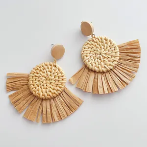 Detail von böhmischen Raffia-Quastenohrringen mit geflochtenem Rattan und Holzelementen