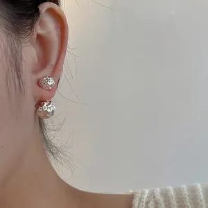 Boucles d'oreilles boules argentées irrégulières avec texture martelée sur modèle