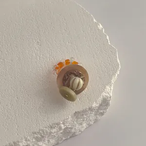 Minimalistischer handgefertigter Muschelring mit Bernsteinperlen auf Marmortablett