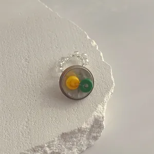 Makroansicht des handgefertigten Perlenrings mit gelben und grünen Details in Klarsicht