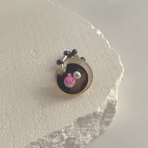 Detailansicht des handgefertigten Harzrings mit braunem Acetat und vintage-rosa Marmorperlen
