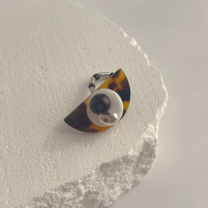 Detailaufnahme eines Harzring mit Schildpattmuster auf weißem Naturstein-Display