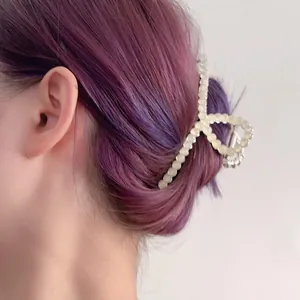 Detail van een witte haarklem met opaalparels op paars haar in een strak en modern design