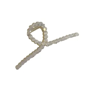 Elegante goudkleurige metalen haarklem met kattenoog kralen in minimalistisch design