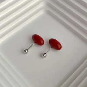Detailed macro view of S925 silver stud earring with glossy red capsule oil drop finish