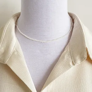 Minimalist 2mm freshwater pearl necklace on model with champagne silk shirt