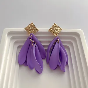 Retro purple petal fringe earrings with gold geometric stud on white ceramic display