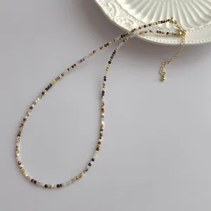 Macro shot of 2mm natural pearl beads necklace with gold adjustable extension chain