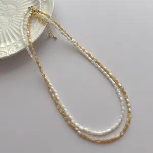 Detail showing double-layered natural shell bead necklace with gold lobster clasp and chain