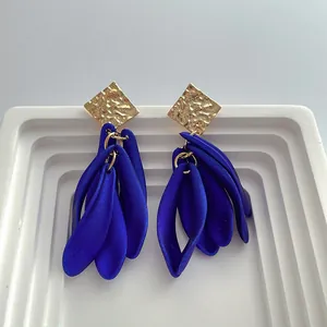 Detailed macro shot of vintage blue resin petal earrings with gold hammered studs