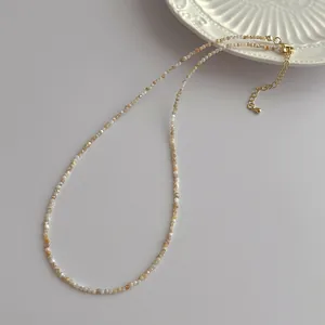 Close-up of 2mm freshwater shell pearl necklace with gold lobster clasp and extension chain