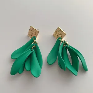 Detail of green leaf earrings with textured gold metal square and matte finish